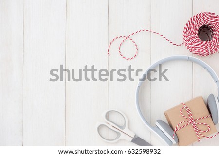 Top view of gift box with headphones on wooden table