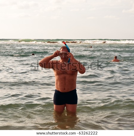 Man in diving mask and snorkelling in the sea .