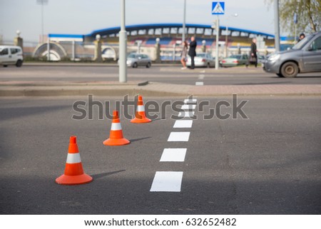 Newly applied road markings. The cones restrict the movement of vehicles.