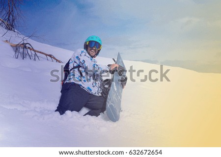 the man in mountains with a snowboard and smiles