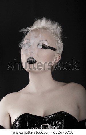 pretty alternative woman smoking on black background