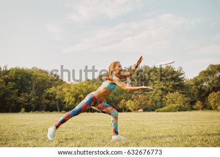 Young athletic girl playing with flying disc in the park. Professional player. Sport concept
