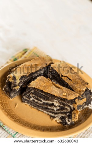 Poppy seed roll cake with copy space over wooden background.