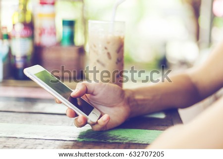 Girl in cafe with mobile phone in hands. Picture with retro toning