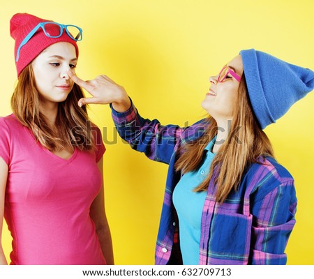 lifestyle people concept: two pretty young school teenage girls having fun happy smiling on yellow background 