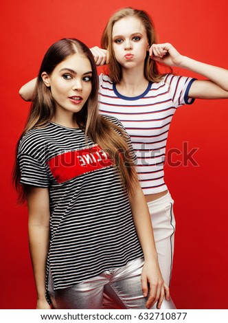 two best friends teenage girls together having fun, posing emotional on red background, besties happy smiling, lifestyle people concept