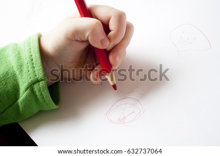 little girl left hand drawing on paper Royalty-Free Stock Photo #632737064