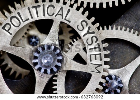 Macro photo of tooth wheel mechanism with POLITICAL SYSTEM letters imprinted on metal surface