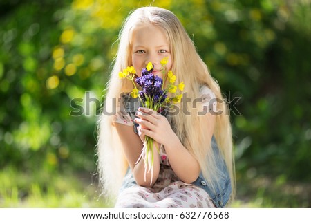 Little cute blonde girl with colorful flowers