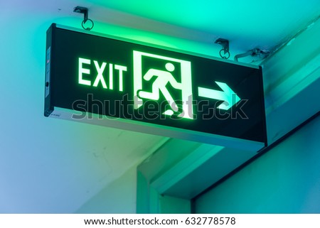 Close-up Exit neon or led sign in corridor point way out of resident apartment building in Hanoi, Vietnam. Lighted wall mounted shining signboard show escape of emergency, urgency, firer. Vintage tone