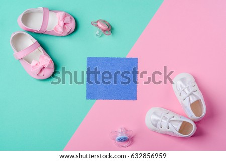 Cute baby girl booties on mint and pink backgrounds, pacifiers, top-view. Place to insert your text. Baby shower.