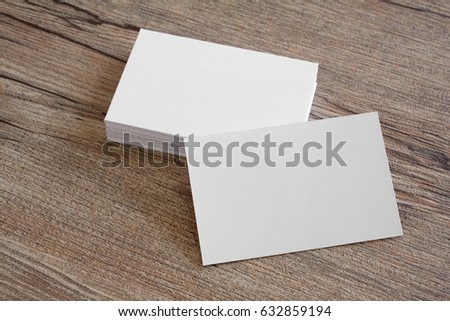 Blank business cards on a wooden background.