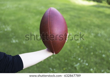 Classic leather rugby ball with laces and stitching on an isolated grass background