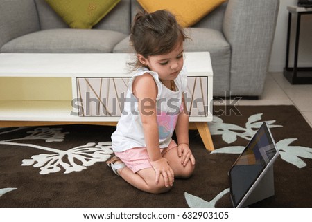 Modern girl sitting on floor and watching cartoon