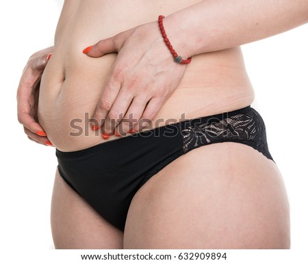 Weight loss, diet, slimming, size concept. Plump woman pinching her fat tummy on a white background. Plus size woman model