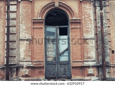 Abandoned old house. Old broken door to the balcony. Ancient down pipes.