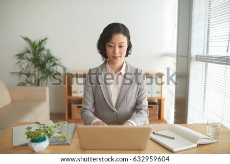 Portrait of attractive Asian business woman working at tablet