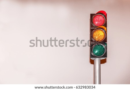 Traffic light  placed on the right side, with a white wall in the background