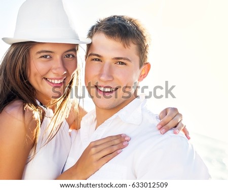 Young couple cuddling on the beach.