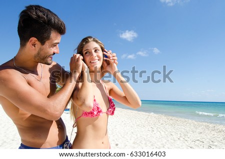 Young couple listening music at the beach