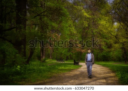 The boy walks in spring garden