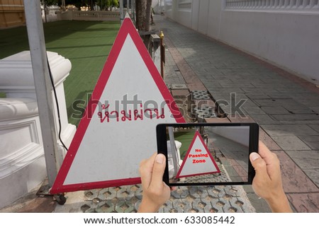 iot,internet of things,traveling concept, man  hold phone and use application of augmented reality technology to translate from local language to english language (???????? is meaning no passing zone)