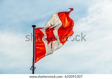 Canadian flag on light blue sky background