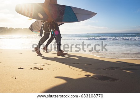 Australian surfers walking along Bondi Beach in the early morning for a surf Royalty-Free Stock Photo #633108770
