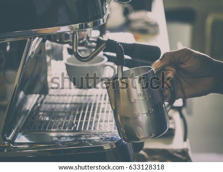 Hand of professional barista making a Latte coffee by Coffee machine.Vintage picture tone.