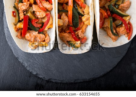 Mexican tacos with pork and vegetables. Al pastor taco on slate tableware. Top view
