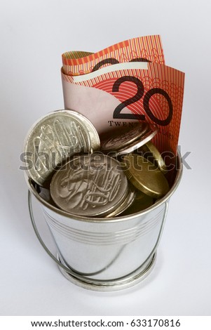 An Australian twenty dollar note and coins in a bucket.