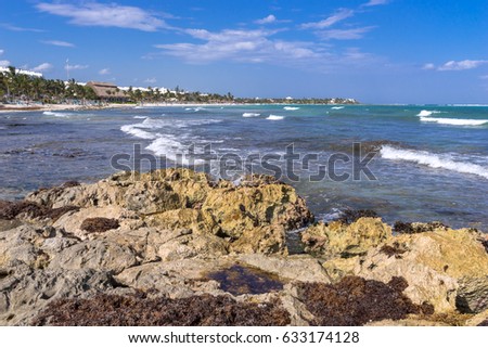 Perspective view to Akumal bay and beaches, Quintana Roo, Mexico. Rock on the front, leading white cup waves in the middle and blue sky background.