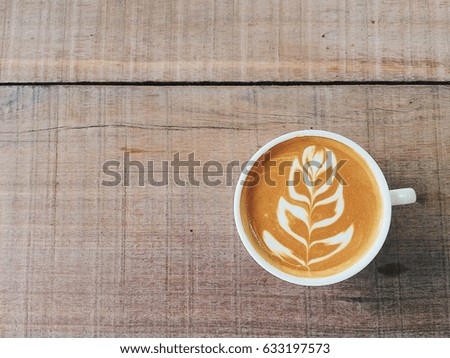 Closeup Cup of coffee ,  beautiful coffee latte art ,coffee on wood table background space for work
