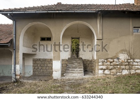 Old abandoned building with arc pillars and a porch in the village