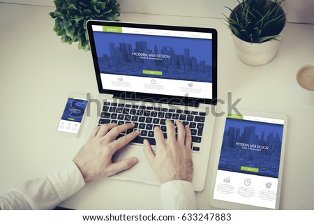 business, technology and responsive design concept: hands writing on a laptop with phone and tablet fresh modern design Royalty-Free Stock Photo #633247883