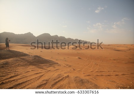 a lady photographer in mountain area, desert and sky background