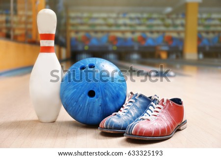 Ball, pin and shoes on floor in bowling club