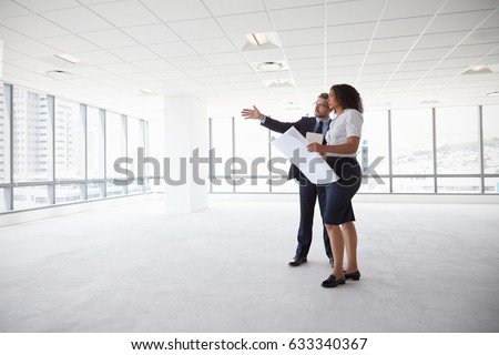 Businesspeople Meeting To Look At Plans In Empty Office Royalty-Free Stock Photo #633340367