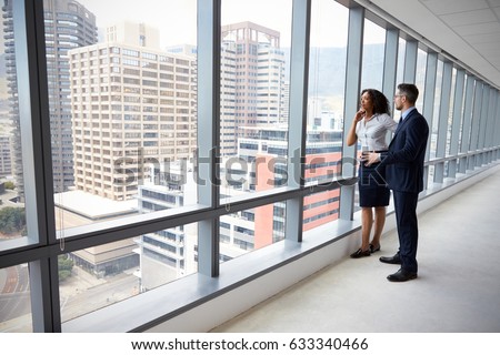 Portrait Of New Business Owners By Empty Office Window Royalty-Free Stock Photo #633340466