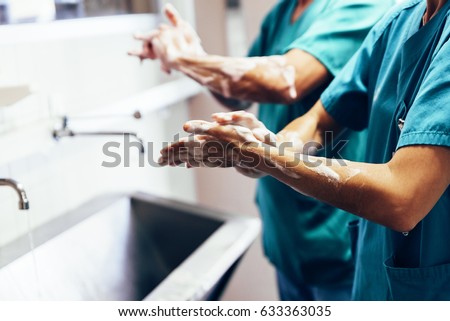 Couple of Surgeons Washing Hands Before Operating. Hospital Concept. Royalty-Free Stock Photo #633363035