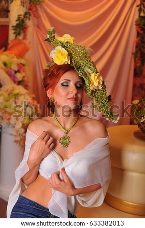 Red-haired girl with a flower composition on her head and professional make-up