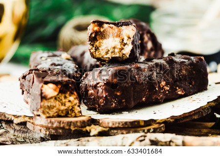 Homemade raw chocolate candy snickers bars. Vegan dessert. Healthy lifestyle and raw food concept Royalty-Free Stock Photo #633401684