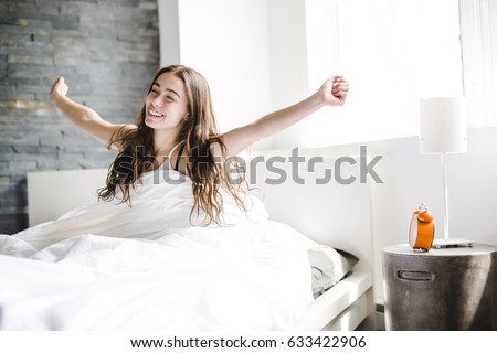 A beautiful young woman with long hair sleeping on bed in bedroom Royalty-Free Stock Photo #633422906