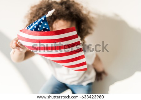 Cute curly african american baby girl with waving american flag