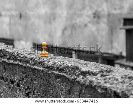Chess piece pawn on the remains of an old concrete wall