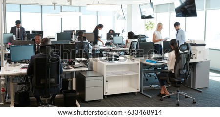 Interior Of Busy Modern Open Plan Office With Staff Royalty-Free Stock Photo #633468914