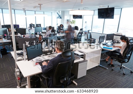 Interior Of Busy Modern Open Plan Office With Staff Royalty-Free Stock Photo #633468920
