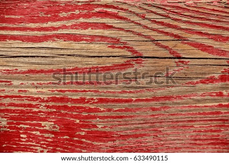 Red cracked painting on wooden surface