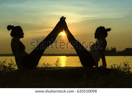 Silhouette women yoga in nature at the sky sunset, near river, color of vintage tone
