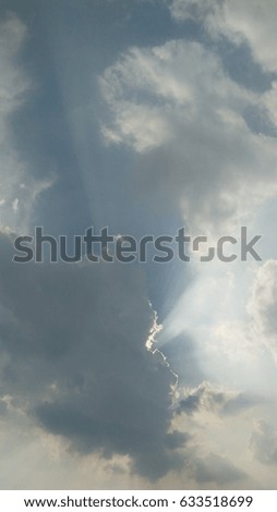 The sun shines through the clouds in the sky.?